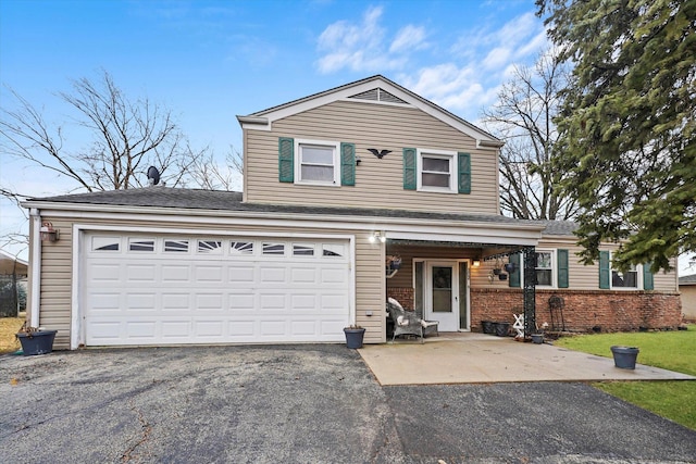 traditional home featuring a front lawn, brick siding, an attached garage, and driveway