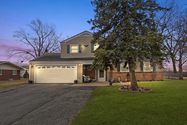 traditional-style home with aphalt driveway, brick siding, a yard, and roof with shingles