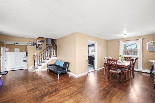 dining area featuring baseboards, stairway, a wall unit AC, wood finished floors, and a baseboard radiator