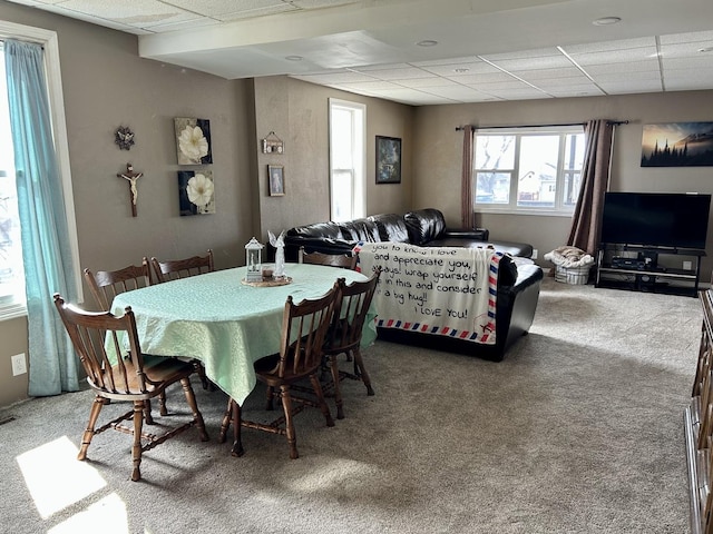 dining area featuring carpet flooring and a paneled ceiling