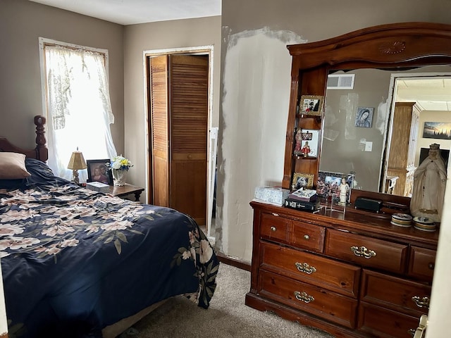 carpeted bedroom with visible vents and a closet