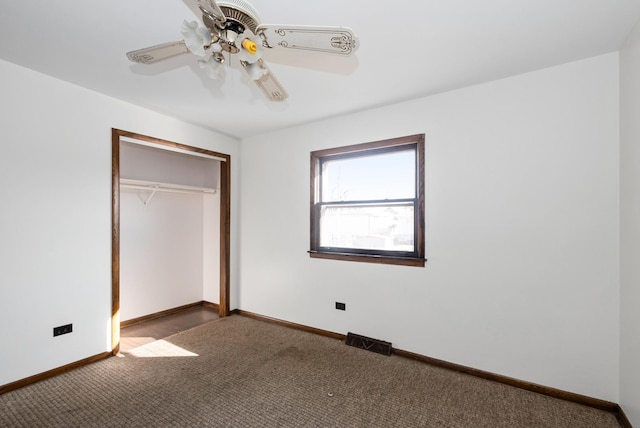 unfurnished bedroom featuring a ceiling fan, carpet, visible vents, baseboards, and a closet