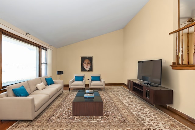 living area with vaulted ceiling and baseboards