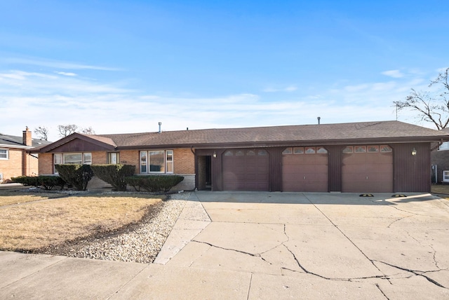 single story home featuring brick siding, concrete driveway, and a garage