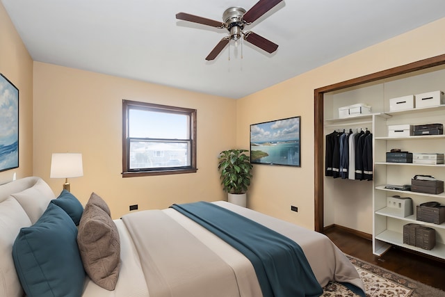 bedroom with a closet, baseboards, dark wood finished floors, and a ceiling fan