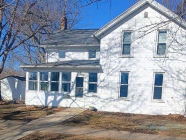 view of front of home featuring a chimney and a sunroom