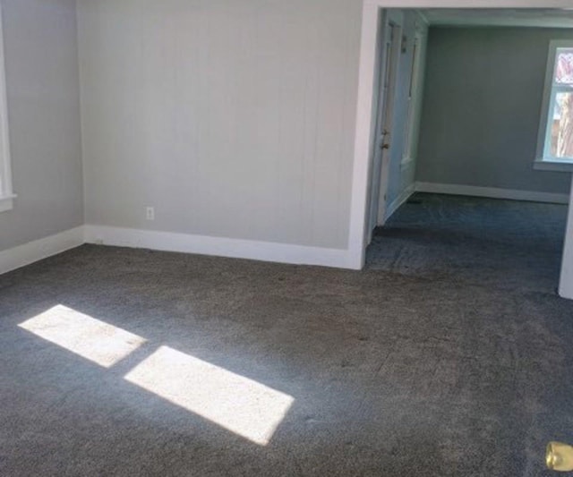 empty room with baseboards and carpet