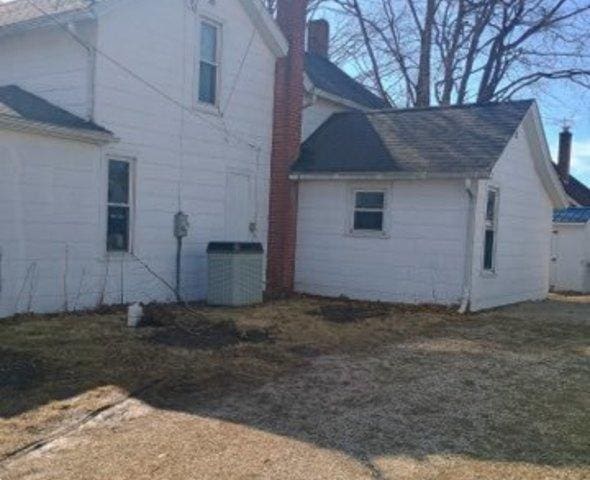 view of side of property with central air condition unit and a chimney