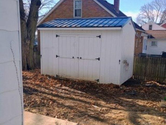 view of shed featuring fence