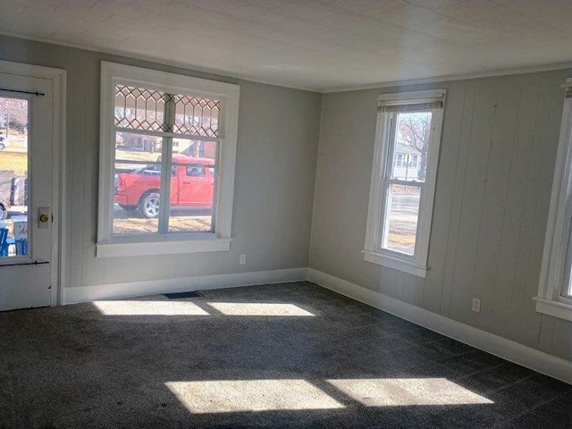 unfurnished room with crown molding, baseboards, and carpet floors