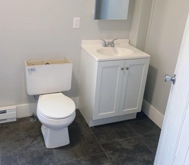 bathroom featuring tile patterned floors, baseboard heating, toilet, and vanity