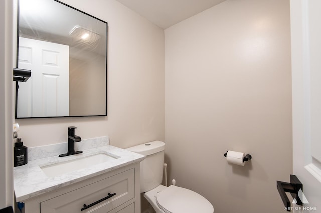 half bathroom with toilet and vanity