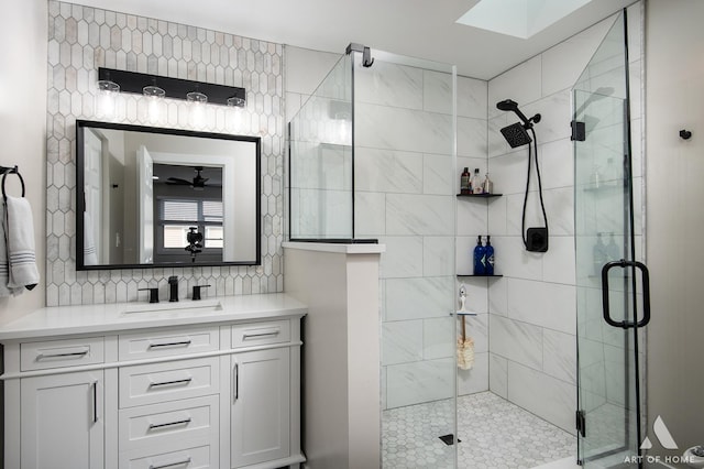 full bath with tasteful backsplash, vanity, and a shower stall