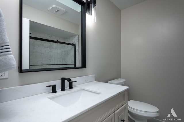 bathroom featuring vanity, toilet, visible vents, and a stall shower