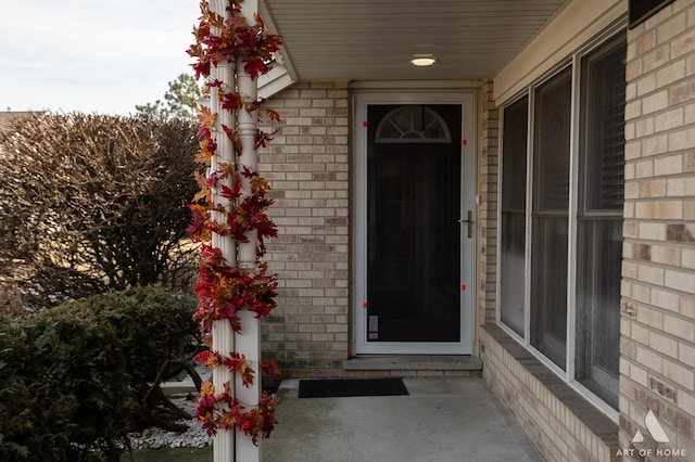 doorway to property with brick siding