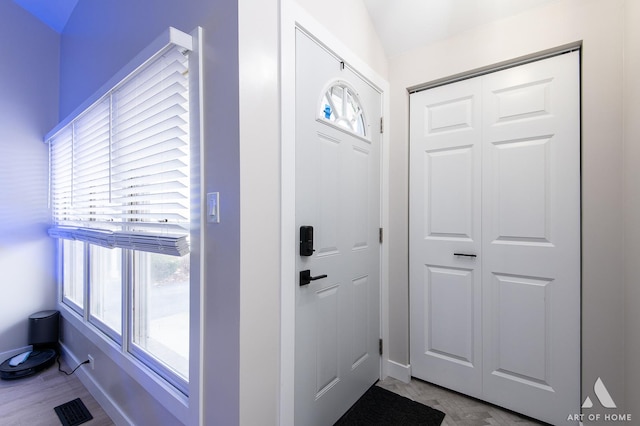 entryway featuring a wealth of natural light, visible vents, baseboards, and wood finished floors