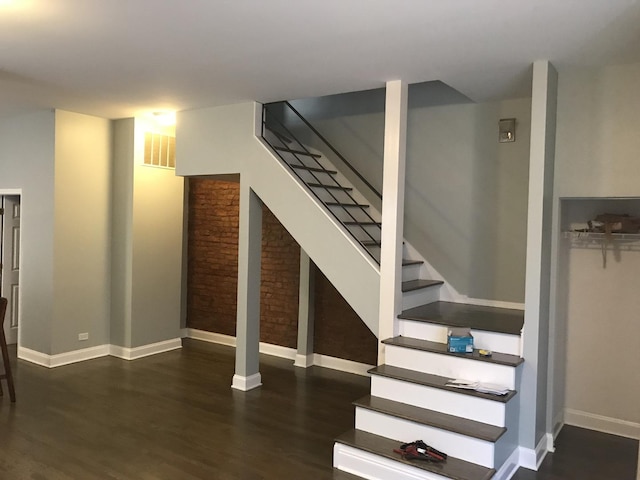 stairway with visible vents, baseboards, and wood finished floors