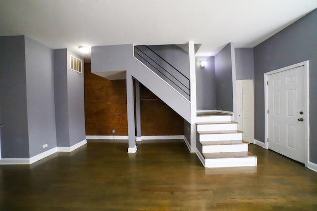 foyer entrance with visible vents, baseboards, wood finished floors, and stairs