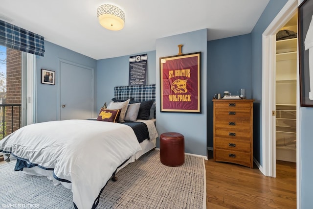 bedroom with baseboards and wood finished floors