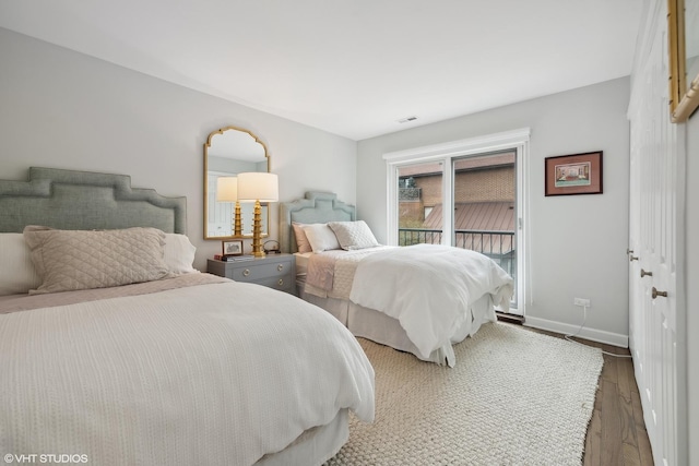 bedroom with access to exterior, visible vents, baseboards, and wood finished floors