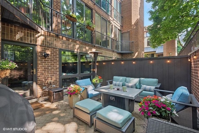 view of patio / terrace with an outdoor living space, a grill, and fence