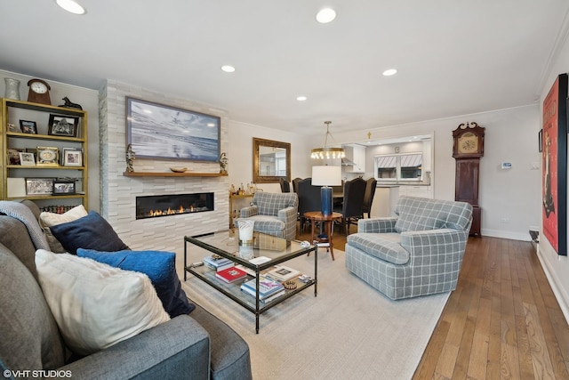 living room with recessed lighting, crown molding, baseboards, and hardwood / wood-style floors