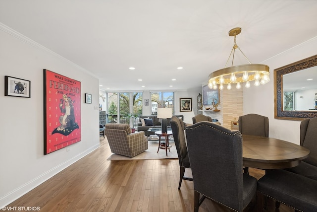 dining space with recessed lighting, baseboards, wood finished floors, and crown molding