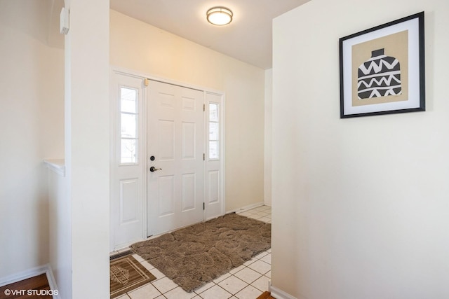 entryway with light tile patterned flooring and baseboards