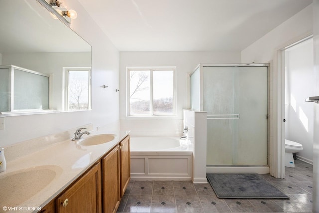 full bathroom with double vanity, a sink, a shower stall, a garden tub, and toilet