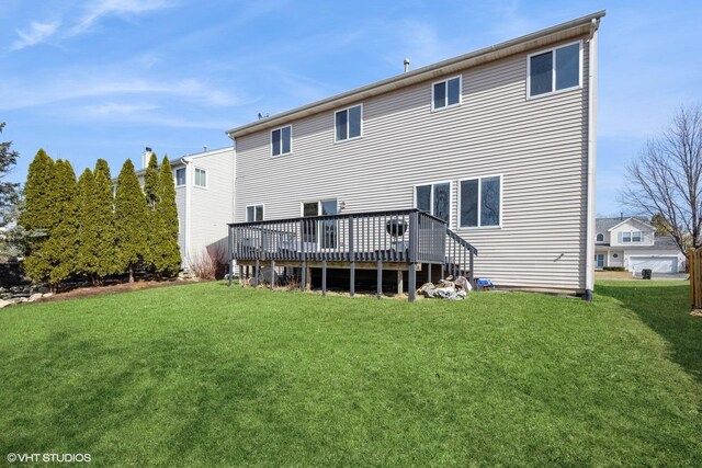 rear view of house featuring a yard and a deck