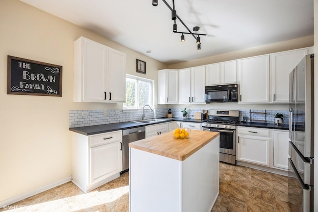 kitchen with wood counters, white cabinetry, backsplash, and stainless steel appliances