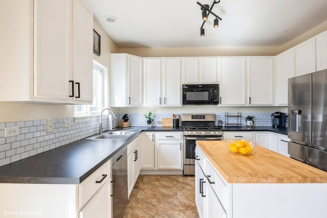 kitchen featuring white cabinetry, wooden counters, stainless steel appliances, and a sink