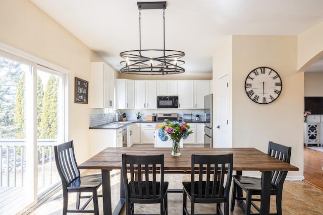 dining room featuring a notable chandelier and baseboards