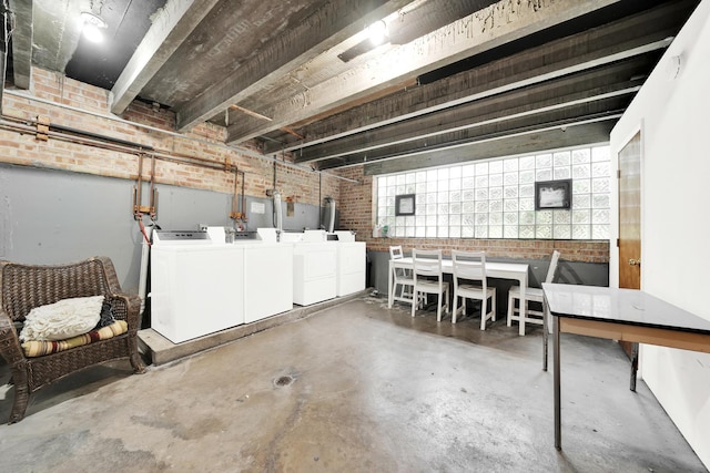 basement featuring washer and dryer and brick wall