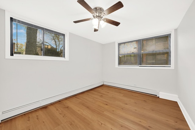 spare room featuring baseboards, a healthy amount of sunlight, and light wood finished floors