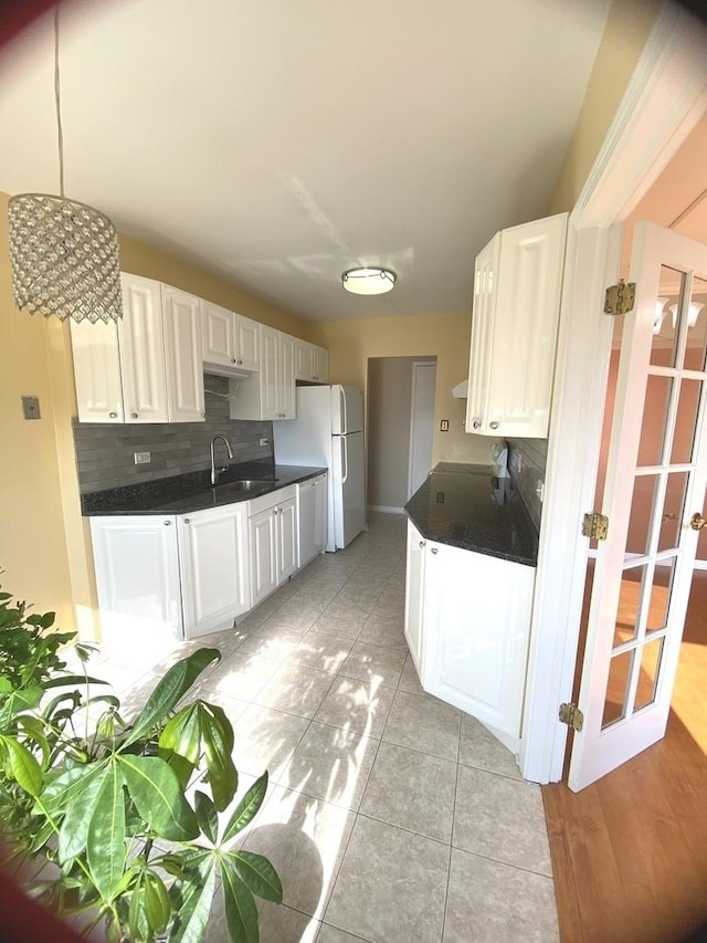 kitchen with dark countertops, backsplash, and a sink