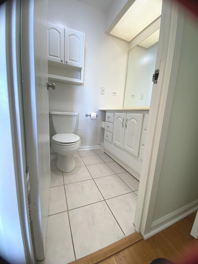 bathroom featuring tile patterned floors, baseboards, toilet, and vanity