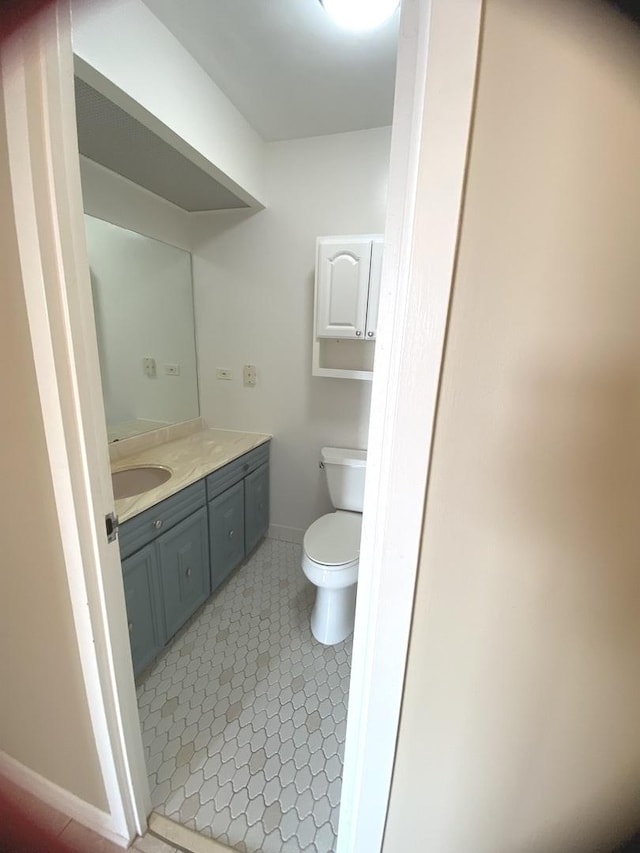 bathroom with vanity, toilet, baseboards, and tile patterned flooring