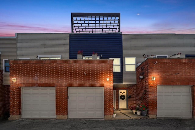 view of front facade featuring brick siding and an attached garage