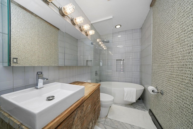 full bathroom featuring vanity, a tile shower, a freestanding bath, tile walls, and toilet