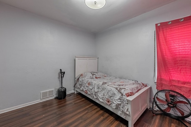 bedroom with visible vents, baseboards, and wood finished floors