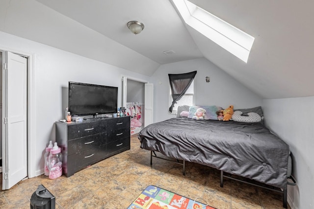 bedroom with lofted ceiling with skylight and stone finish flooring