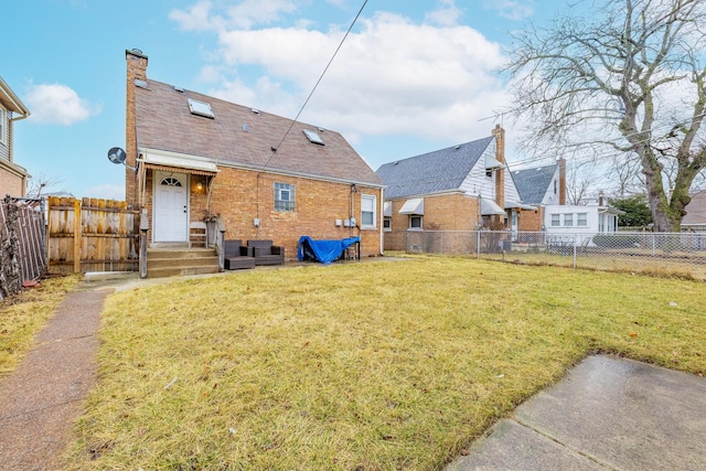 rear view of house featuring brick siding, a lawn, a chimney, and a fenced backyard