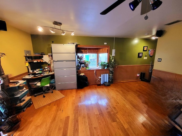 office area with visible vents, wainscoting, a ceiling fan, and wood finished floors