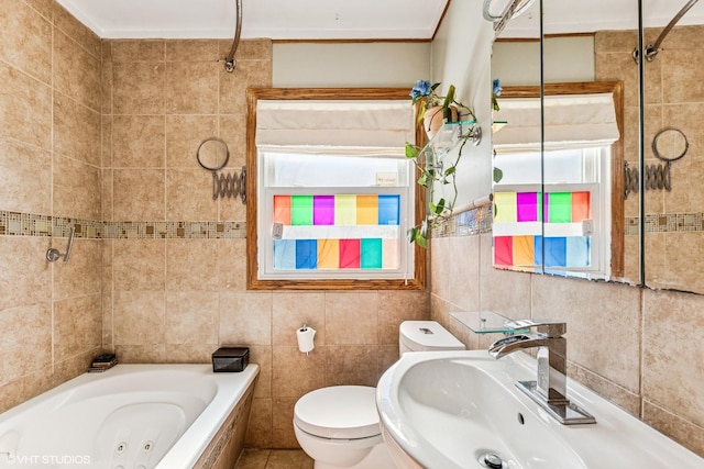 bathroom featuring a sink, tile walls, toilet, and a tub with jets