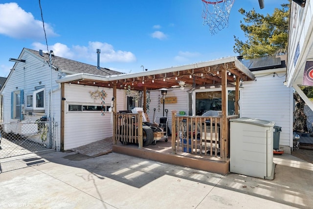 view of front of property featuring fence, roof with shingles, and a wooden deck