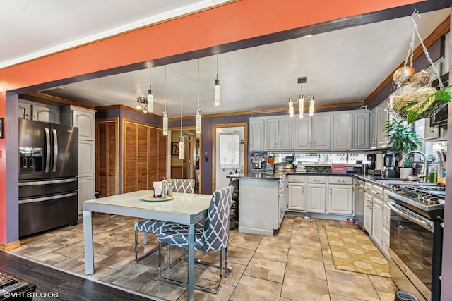 kitchen with dark countertops, crown molding, pendant lighting, stainless steel appliances, and a sink