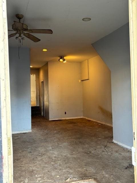 spare room featuring concrete floors and a ceiling fan