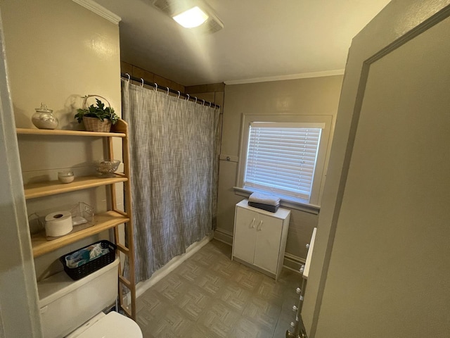 bathroom with a shower with shower curtain, baseboards, toilet, and crown molding