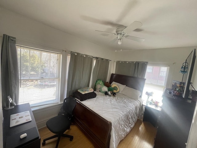 bedroom with a ceiling fan, wood finished floors, and baseboards